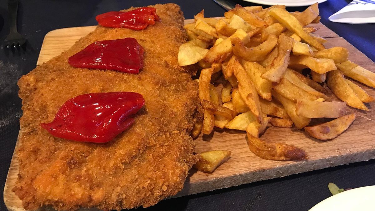 Un cachopo acompañado de piquillos.