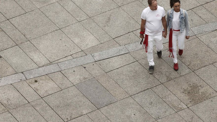 Dos personas con la vestimenta típica de los Sanfermines pasan por la Plaza del Castillo. EFE/Jesús Diges