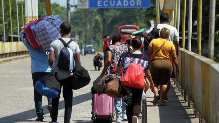Fotografía fechada ayer domingo, 25 de agosto de 2019, que muestra a una familia venezolana mientras trata de cruzar el paso fronterizo de San Miguel (Ecuador).