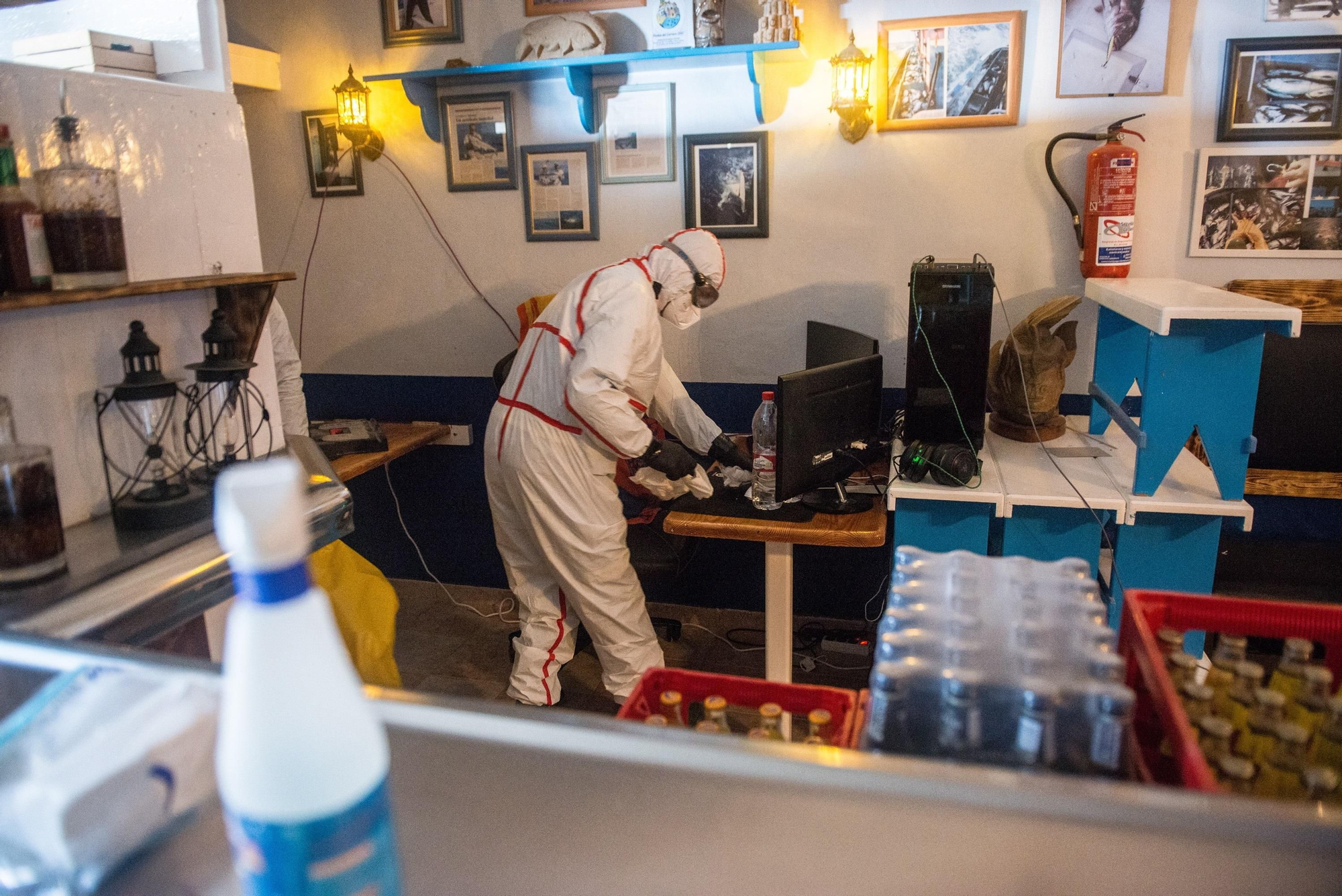 Un operario del Ayuntamiento de Teguise desinfecta un comercio en La Graciosa en el primer día de la fase 1 de desescalada.
