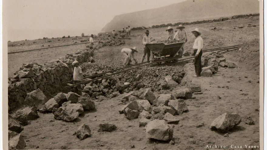 Trabajadores durante la construcción de los muros de mampostería para el cultivo del plátano. En ella se puede observar el morro de El Time al fondo. (Archivo Casa Yanes)