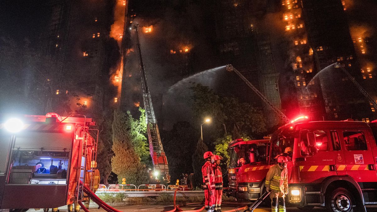 Efectivos de bomberos a pie de calle el el incendio en Tai Po, Hong Kong.