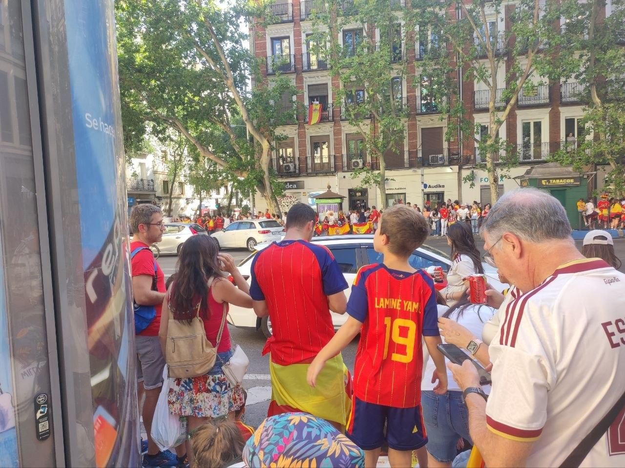 Un niño con la camiseta de Lamine Yamal busca a sus ídolos en la calle Princesa de Madrid.