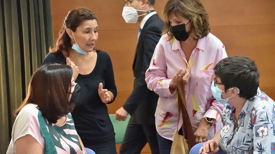 Carmen Martínez (PSPV), de pie a la derecha, conversa con Estefanía Blanes y Pilar Lima (sentadas), de Unides Podem-EUPV.