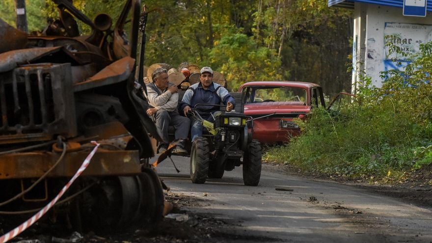 Vecinos de la localidad de Sviatohirsk, en la región de Donetsk, transportan trozo de leña en un tractor.