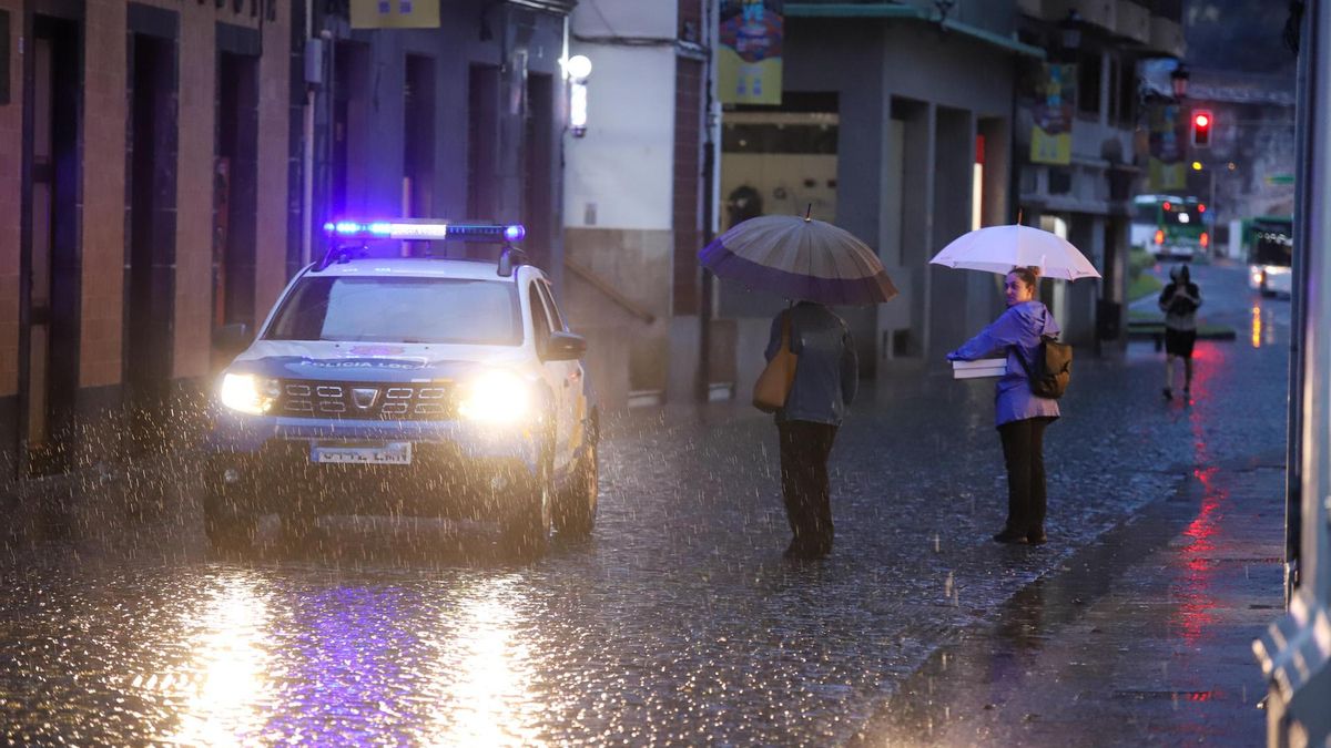 Varias personas se protegen del aguacero en Santa Cruz de La Palma. EFE/Luis G. Morera