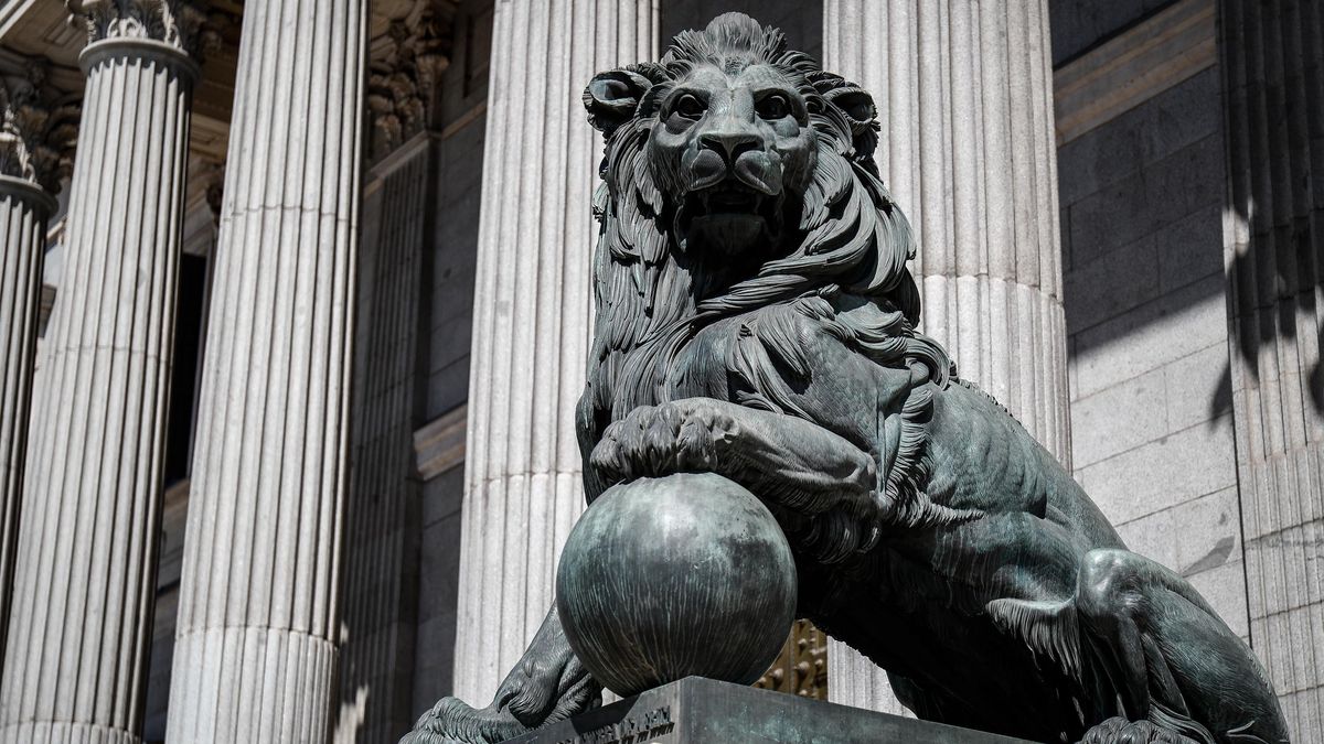 Archivo - Uno de los emblemáticos leones que se encuentran delante de la fachada del Congreso de los Diputados en la Plaza de las Cortes de Madrid.