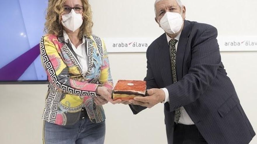 La diputada foral de Fomento del Empleo, Comercio y Turismo, Cristina González, y el presidente de la Asociación de Pastelerías y Confiterías Artesanales de Álava, Luis López de Sosoaga, presentan el pastel 'Arabatxo'.