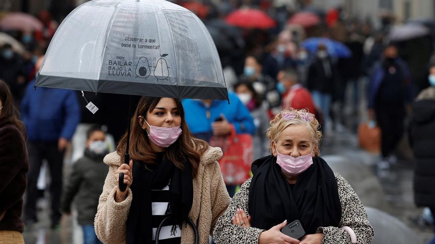 Varias personas caminan con mascarillas por la calle Preciados este viernes cuando el país ha llegado a la Navidad con cifras récord de contagios y con la vuelta de la mascarilla obligatoria en exteriores, además de con la imposición de restricciones más duras en algunas comunidades autónomas para frenar la covid 19, que mantiene su tendencia ascendente en esta sexta ola.