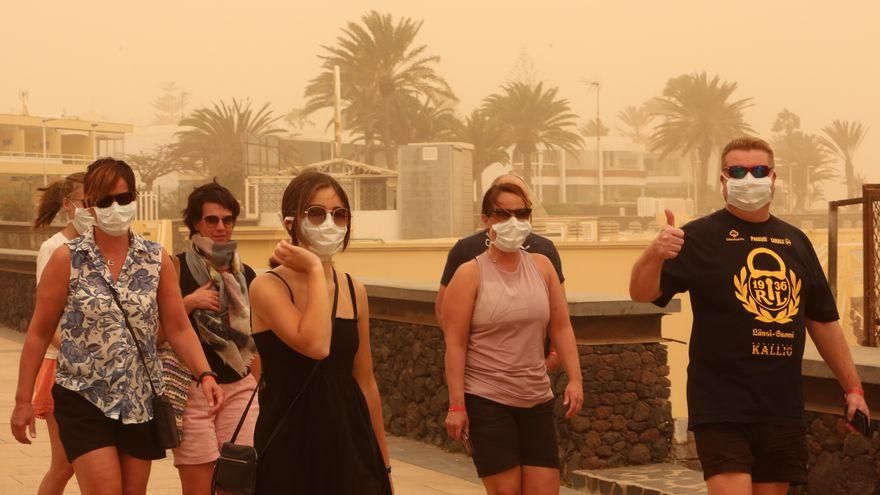 Varias personas pasean en el sur de Gran Canaria en un día de intensa calima