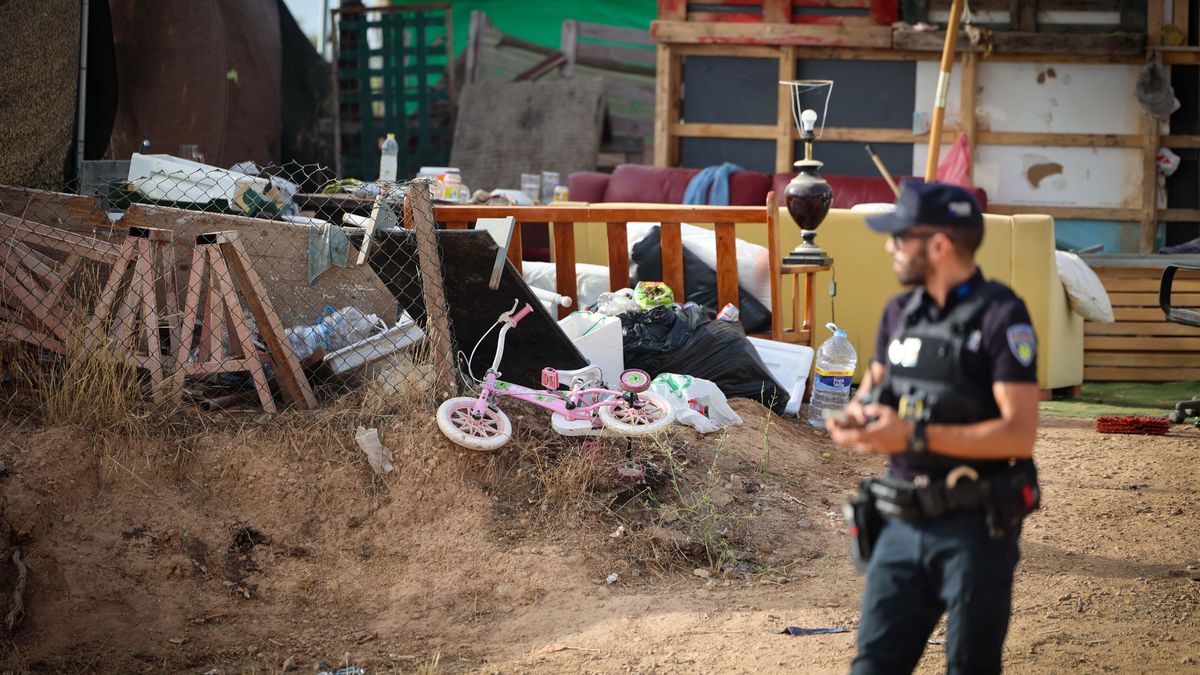 Un policía asiste al desahucio. Al fondo, los enseres personales de los residentes, entre ellos, una bicicleta.