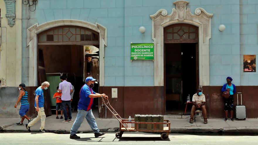 Fotografía de archivo de un hombre mientras camina con una carretilla frente a un policlínico en La Habana (Cuba)