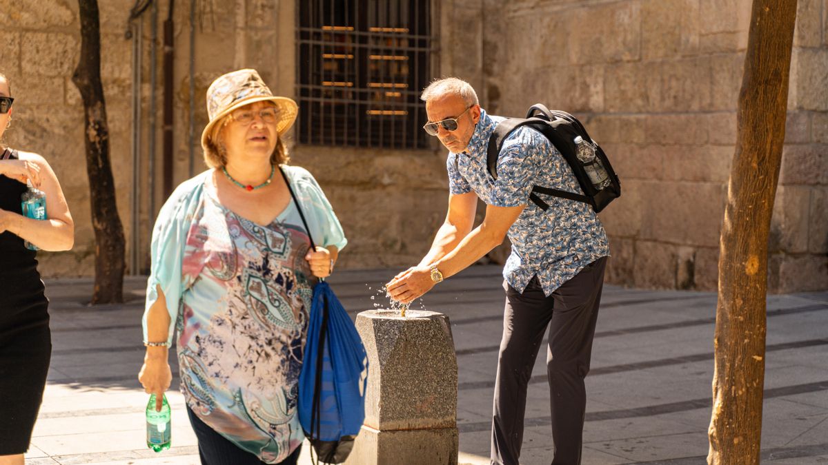 Un turista se refresca en una fuente en Córdoba.