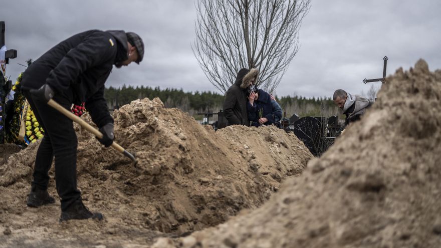 Una pareja llora la muerte de su padre en Bucha.