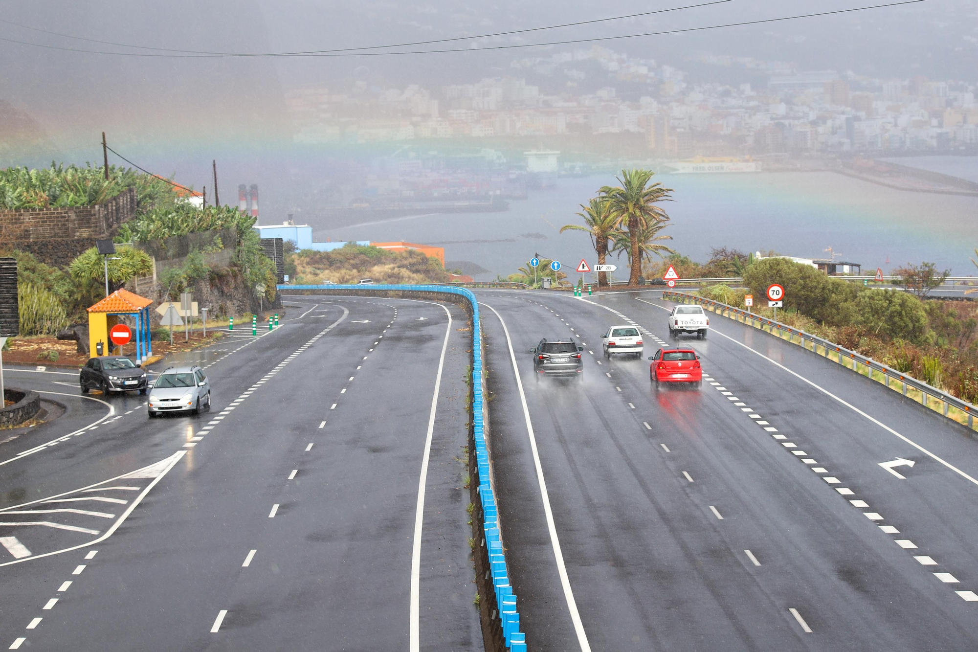 La Palma ha recibido este miércoles los primeros efectos del paso por Canarias de la borrasca Claudia, en forma de lluvias que han descargado 45 litros de agua por metro cuadrado en varios puntos de la isla. En la imagen, la carretera de acceso a Santa Cruz de La Palma, la capital (al fondo).