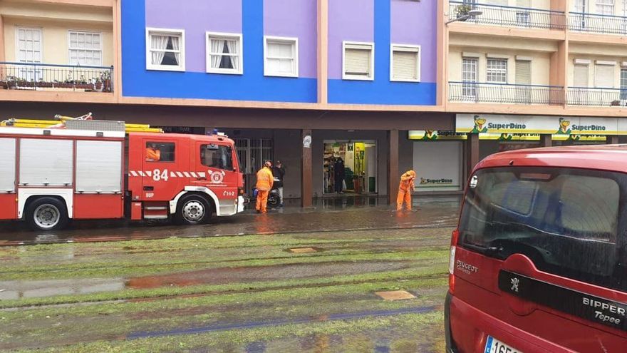 Miembros del cuerpo de bomberos actúan en una calle afectada por la lluvia en La Laguna