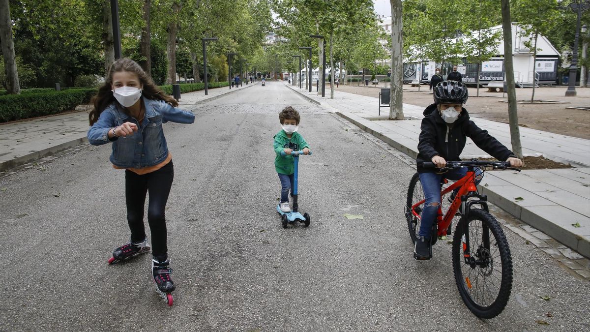 Tres niños practican deporte al aire libre protegidos con mascarillas, el primer día en el que los menores de 14 años pueden salir. En Granada (Andalucía ,España) a 26 de abril de 2020.