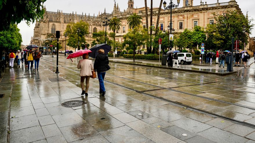 Viandantes caminando en Sevilla en una jornada marcada por las lluvias.