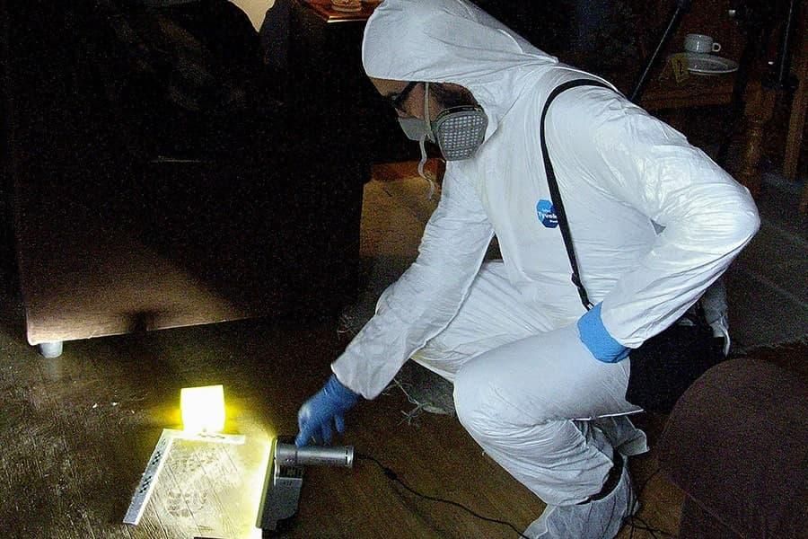 Un agente de la Policía Científica sacando una huella