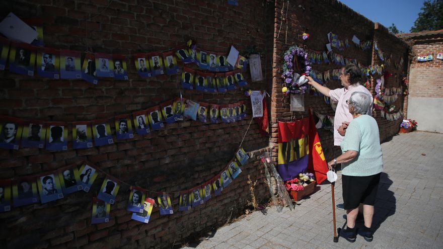 Dos personas en las inmediaciones del panteón de las 13 rosas, durante un homenaje en el 83º aniversario de su fusilamiento, en el Cementerio de la Almudena