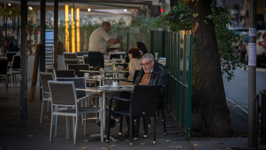 Un hombre lee en una terraza durante el primer día del inicio del primer tramo de la desescalada de la segunda ola por el coronavirus en Barcelona, Catalunya (España), a 23 de noviembre de 2020. Desde hoy, bares y restaurantes podrán abrir de 6.00 a 21.30 para consumo en el establecimiento, el aforo en el interior estará limitado al 30%, y no podrá haber más de cuatro comensales por mesa --excepto si son del mismo grupo de convivencia--.