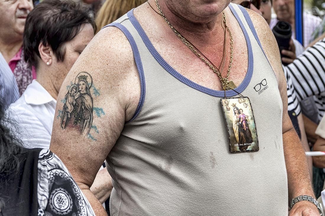 Uno de los participantes (con un tatuaje y un escapulario de La Virgen) en la procesión de El Carmen, que tiene lugar en el Barrio Pesquero de Santander con motivo de su festividad. | ROMÁN GARCÍA (16/07/2014)