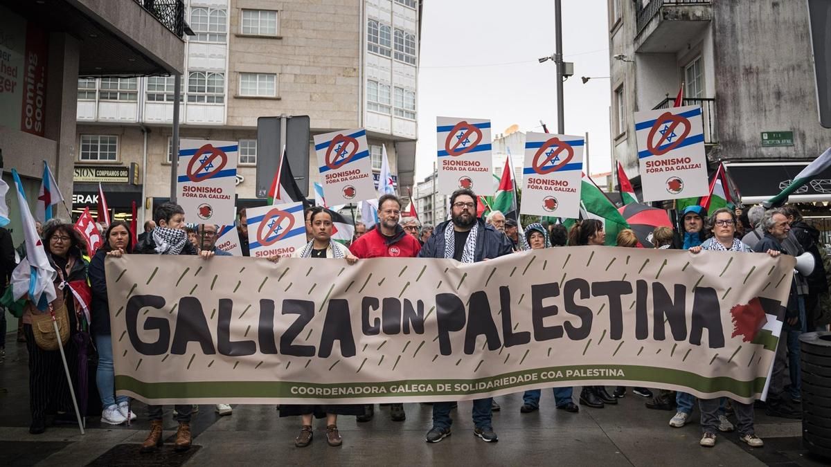 Manifestantes con pancartas durante las protestas ante la presencia de Ehud Olmert en el Foro La Toja en la Illa de la Toja