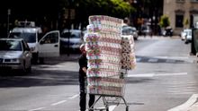 Un trabajador transporta numerosos rollos de papel higiénico en un carro de la compra dirección a un comercio en el centro de Málaga.