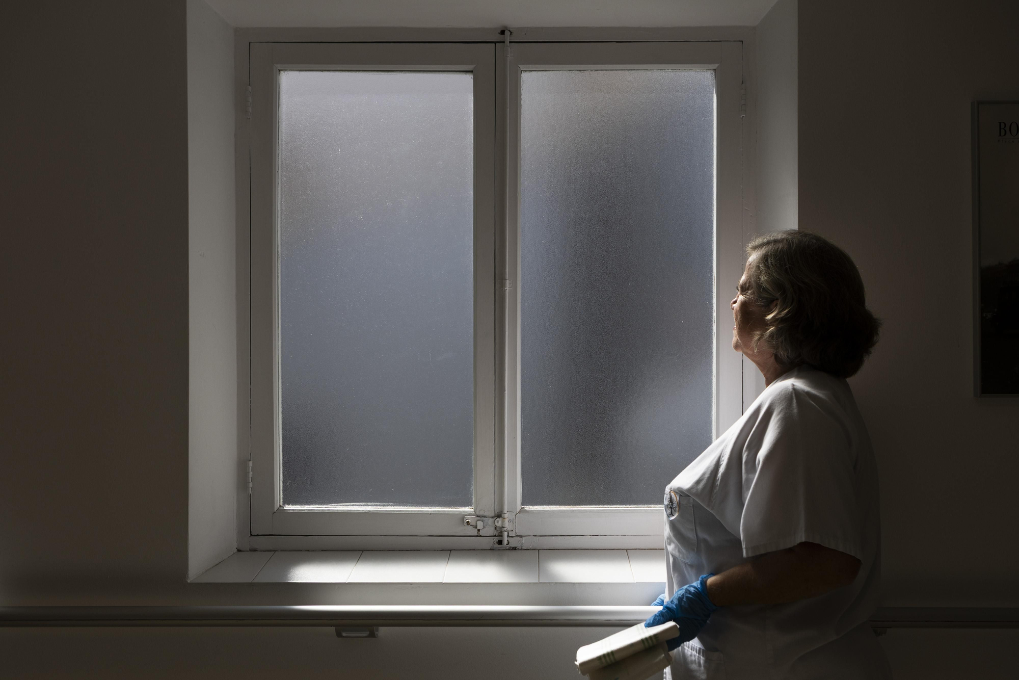 Ana, enfermera del Hospital General, contempla la luz que se filtra por la ventana de la sala de cuidados paliativos