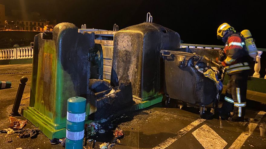 En la imagen, un bombero y  los contenedores afectados por el incendio.