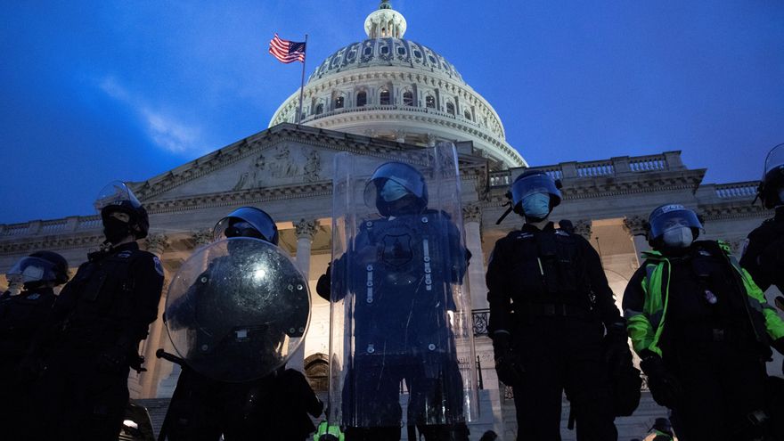 Agentes antidisturbios custodian la entrada del Capitolio de EE.UU. tras desalojar a los cientos de seguidores del presidente Donald Trump que irrumpieron en él por la fuerza