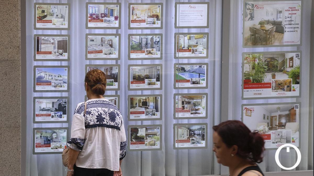 Una mujer viendo carteles de pisos en venta y en alquiler en una inmobiliaria