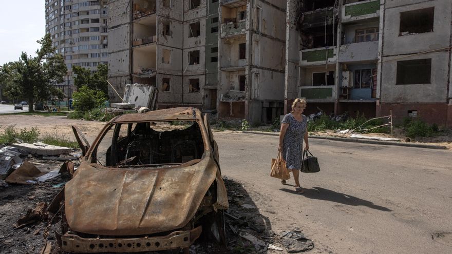 Una mujer pasa este lunes junto a un coche quemado y un edificio residencial dañado en Chernihiv, en el norte de Ucrania. EFE/EPA/ROMAN PILIPEY