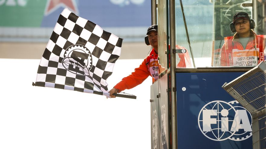 Un agente de la FIA hondea la bandera de cuadros durante el Gran Premio de China de Fórmula 1 de 2026.
