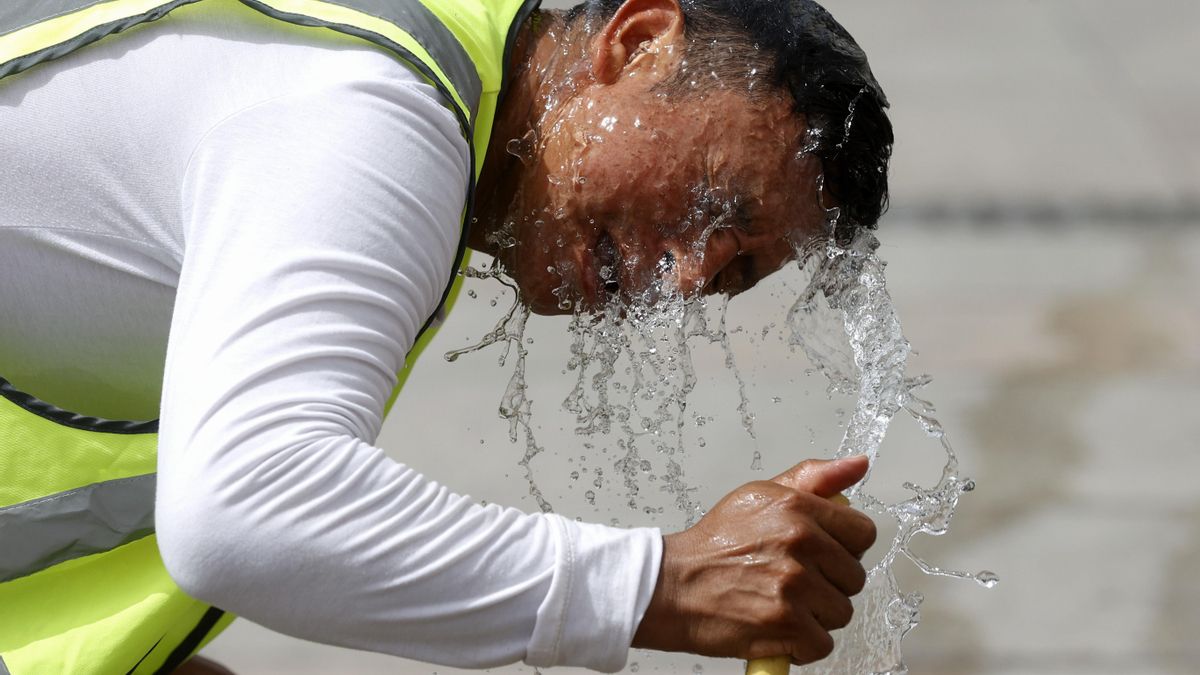 Un trabajador se refresca con una manguera en una calle de Madrid. EFE/ Juan Carlos Hidalgo