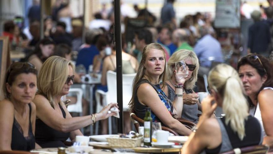 Varios turistas se refrescan en una terraza junto a La Lonja de Valencia EFE/Manuel Bruque/Archivo .