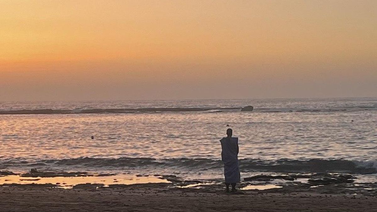 Persona observa atardecer en la Playa de Las Canteras.