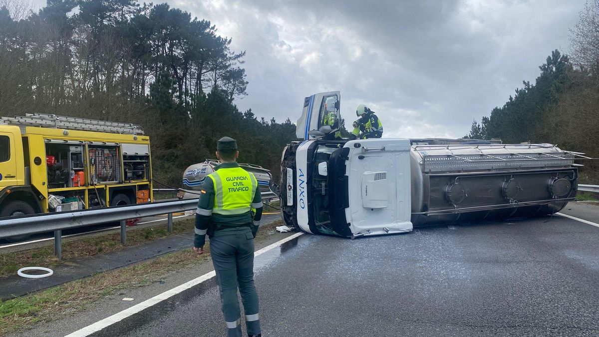 Un agente de la Guardia Civil junto al camión volcado en la A 8, en el concejo asturiano de El Franco.