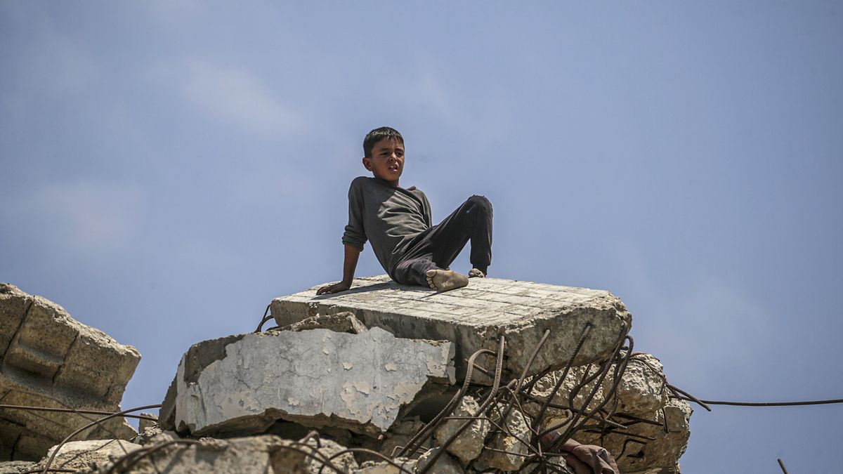 Un niño palestino se sienta sobre los escombros de un edificio destruido en la parte norte de la Franja de Gaza. EFE/MOHAMMED SABER