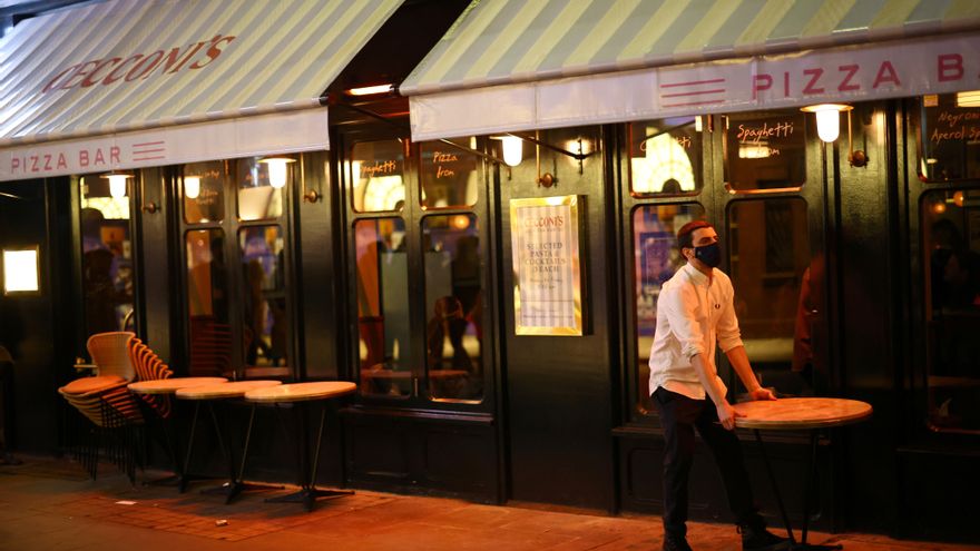 Un camarero echando el cierre a su bar en el Soho, Londres