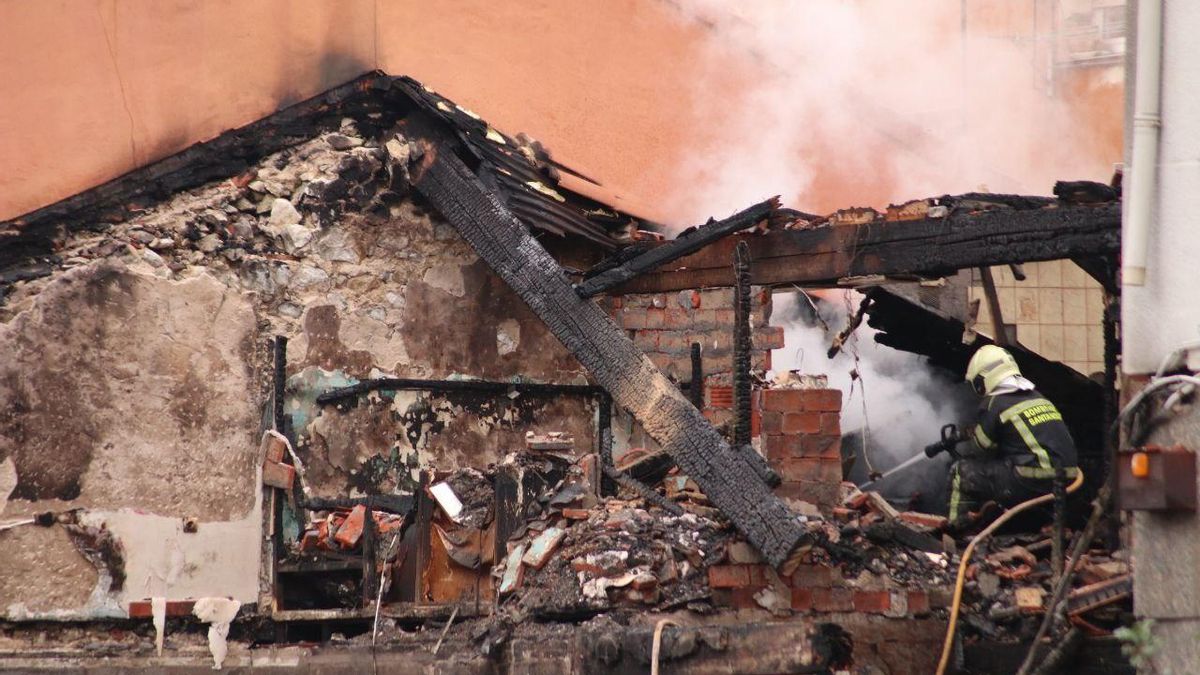 Los bomberos enfrían el edificio calcinado tras el derrumbe.