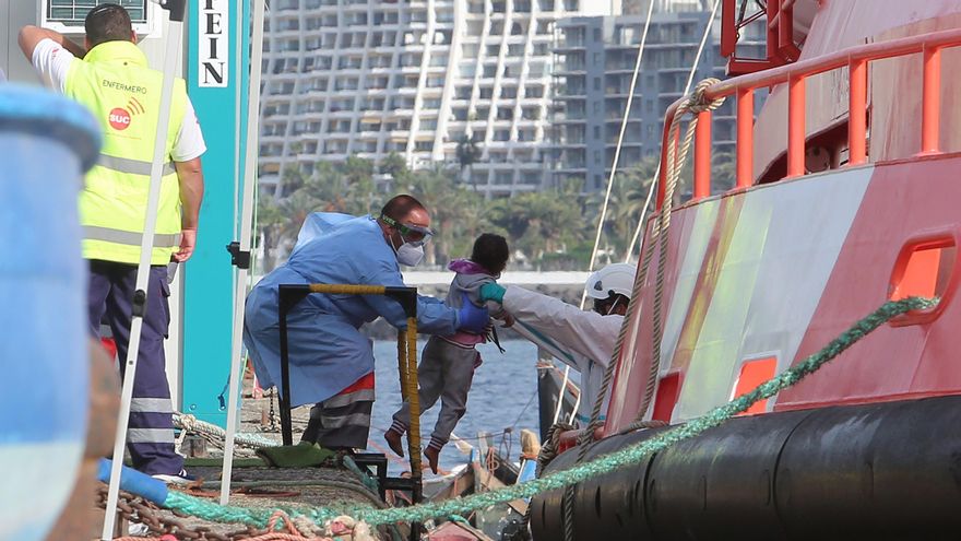 Personal de Salvamento Marítimo ayuda a desembarcar a un menor en el muelle de Arguineguín.