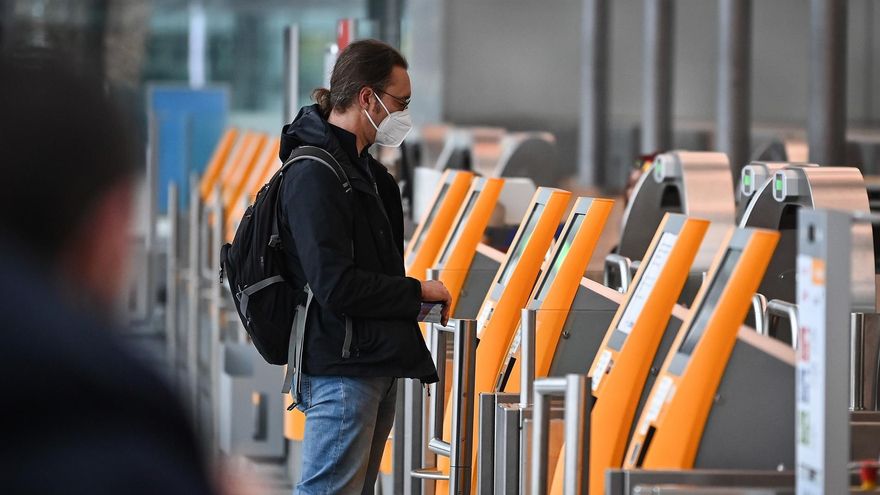 A traveller wearing an ffp-2 face mask checks in at the airport in Munich, Germany, 27 November 2021. The spread of a new potentially more dangerous variant of coronavirus, the B.1.1.529 Coronavirus variant Omicron, in southern Africa has caused international concern. Experts fear that it could be highly contagious because of an unusually large number of mutations and could also penetrate the protective shield of vaccines more easily. Many countries placed travel ban on flights to and from Southern African countries. (Alemania)