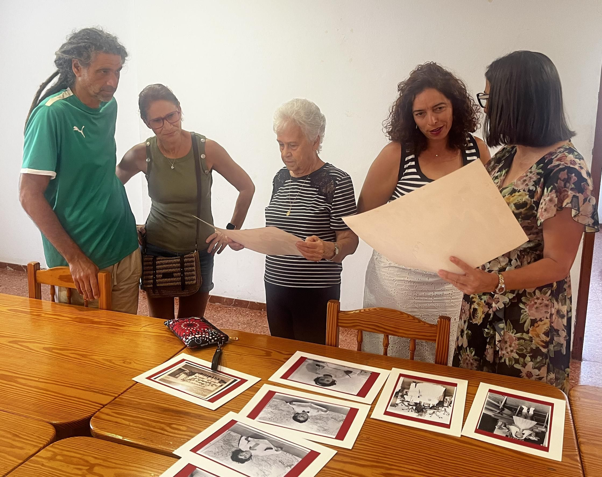 Un grupo de vecinos viendo fotos en la Asociación Rosa Nueva.