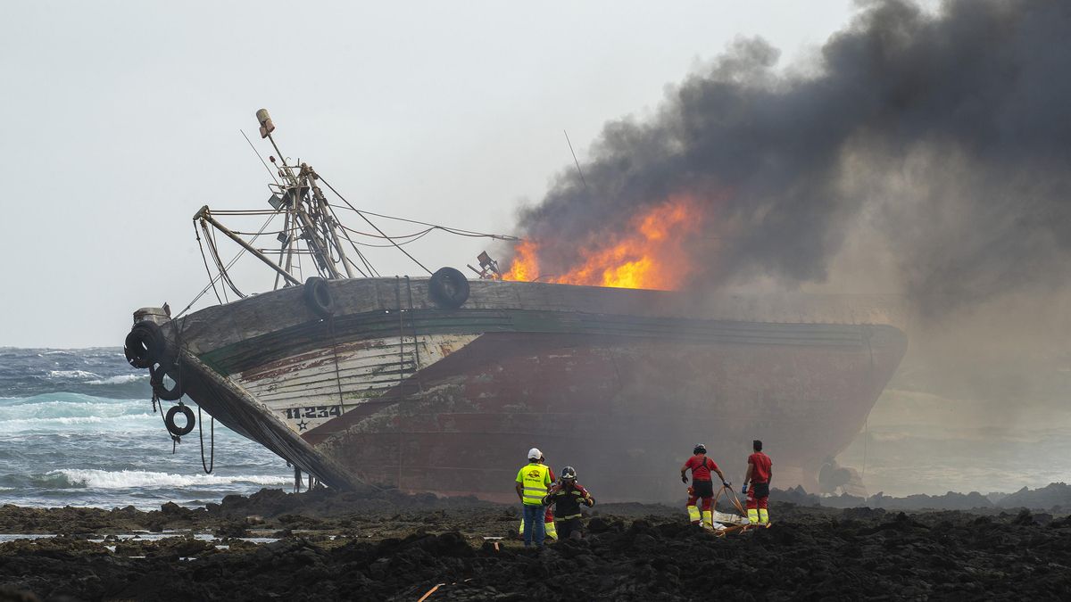 Los bomberos durante el incendio del atunero encallado en Órzola