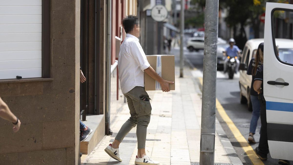 Un agente saca documentación de una de las localizaciones en la que supuestamente se está realizando registros.