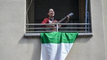 Una mujer canta y toca la guitarra en su balcón de Milán