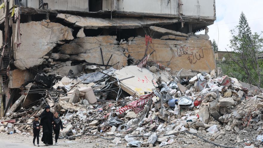 Una mujer y dos niños pasan junto a los escombros de un edificio bombardeo en Jibchit, en el sur del Líbano, el 21 de abril.