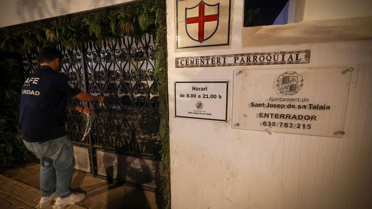 Un vigilante cierra la puerta del cementerio de Sant Jordi para impedir que personas en situación de calle duerman en él.