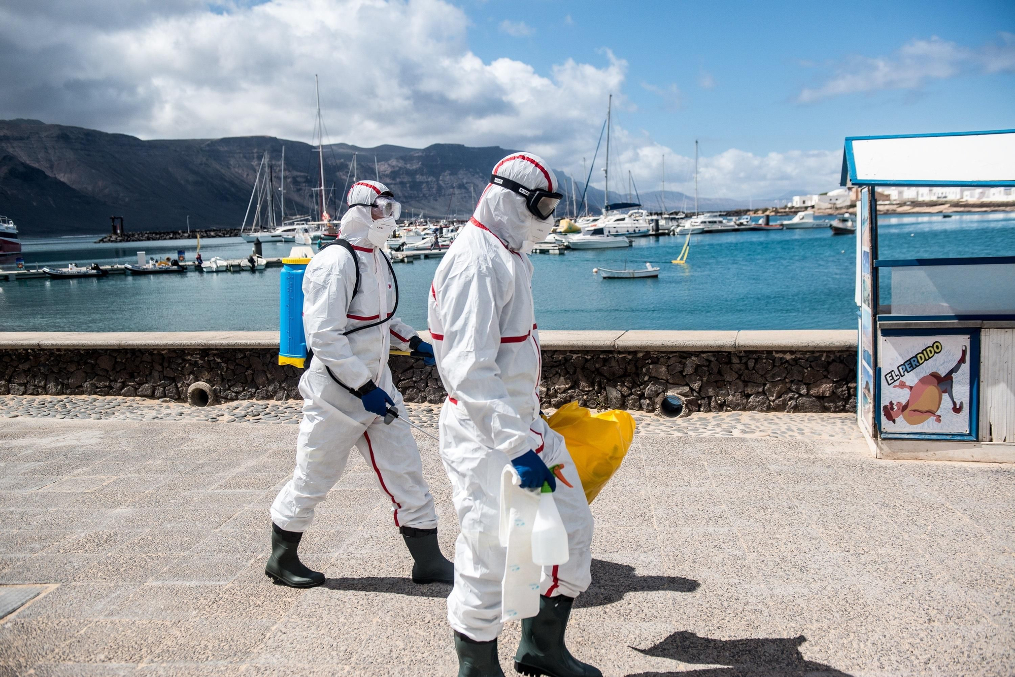 Dos operarios del Ayuntamiento realizan labores de desinfección en La Graciosa en el primer día en la fase 1 de desescalada.